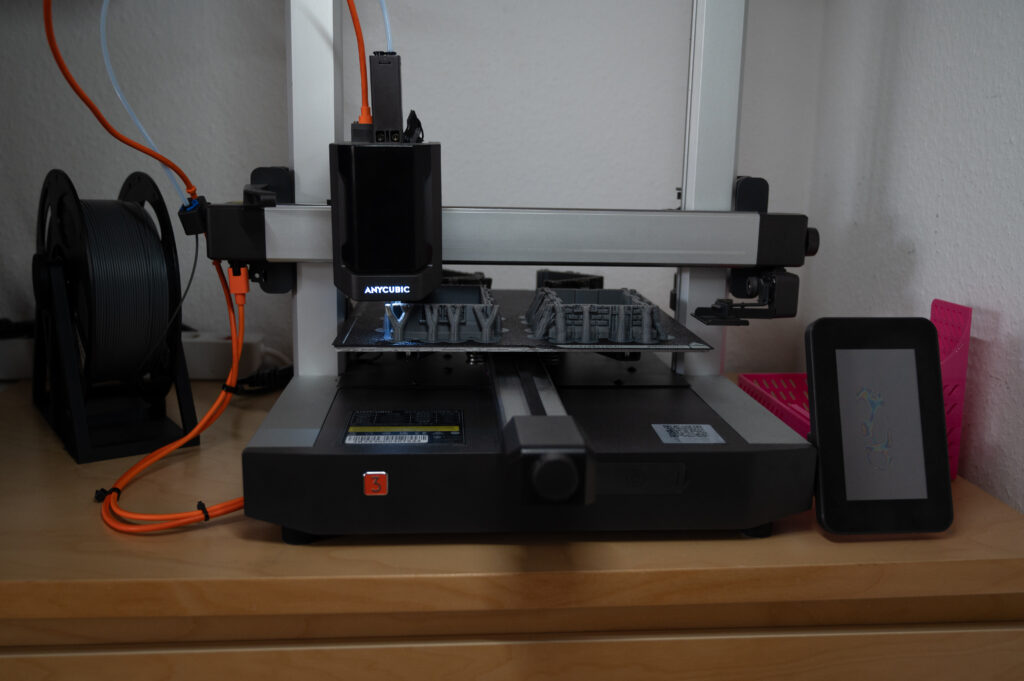 Anycubic Kobra 3 FDM-3D-Drucker beim Drucken mehrerer grauer Bauteile