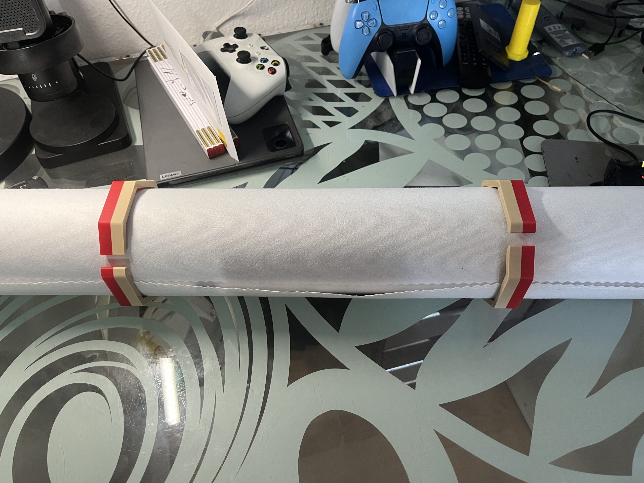 Zwei rot-beige Leinwandklemmen halten eine aufgerollte Diamond-Painting-Leinwand zusammen