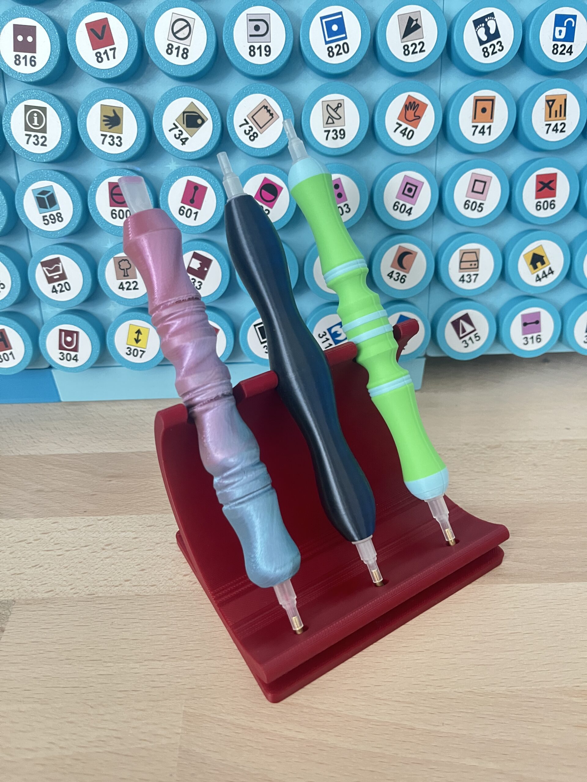 Roter Diamond-Painting-Stifthalter mit drei eingesetzten Beispielstiften; Stifte und Dekoration sind nicht enthalten